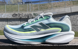 New Balance Ellipse review: running shoe in blue-teal gradient with neon-yellow accent, placed on a wooden railing outdoors.